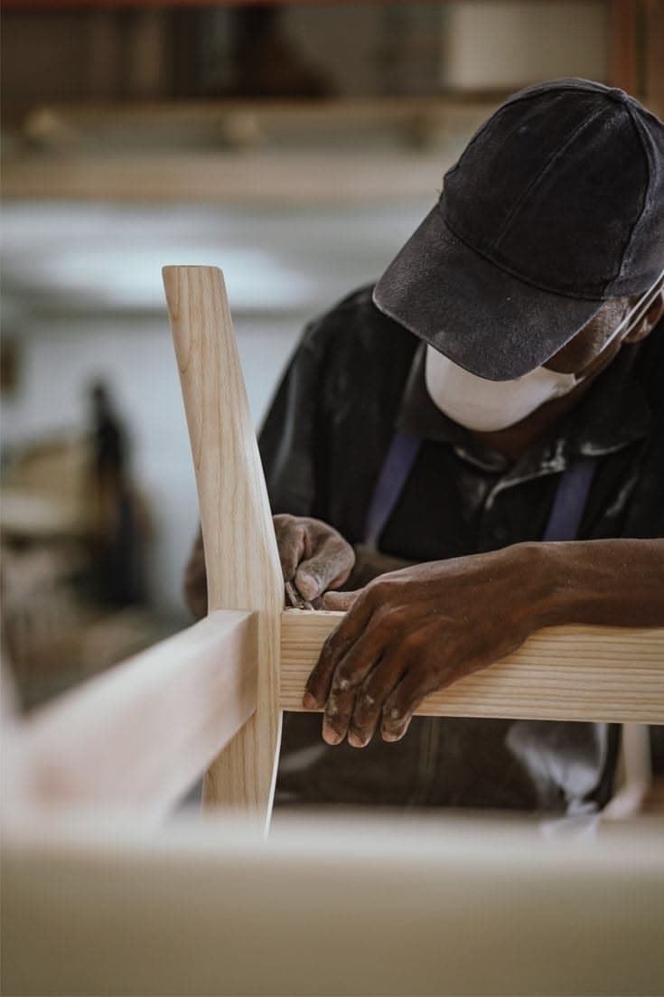 A craftsperson building casework at a millwork shop bench